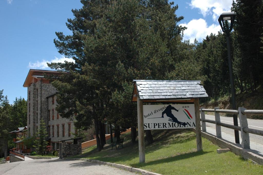 um sinal no lado de uma estrada ao lado de uma cerca em Hotel Supermolina em La Molina