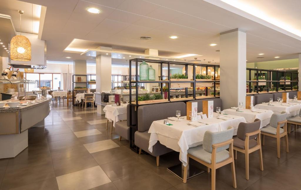 a dining room with white tables and chairs at AQUA Hotel Bertran Park in Lloret de Mar