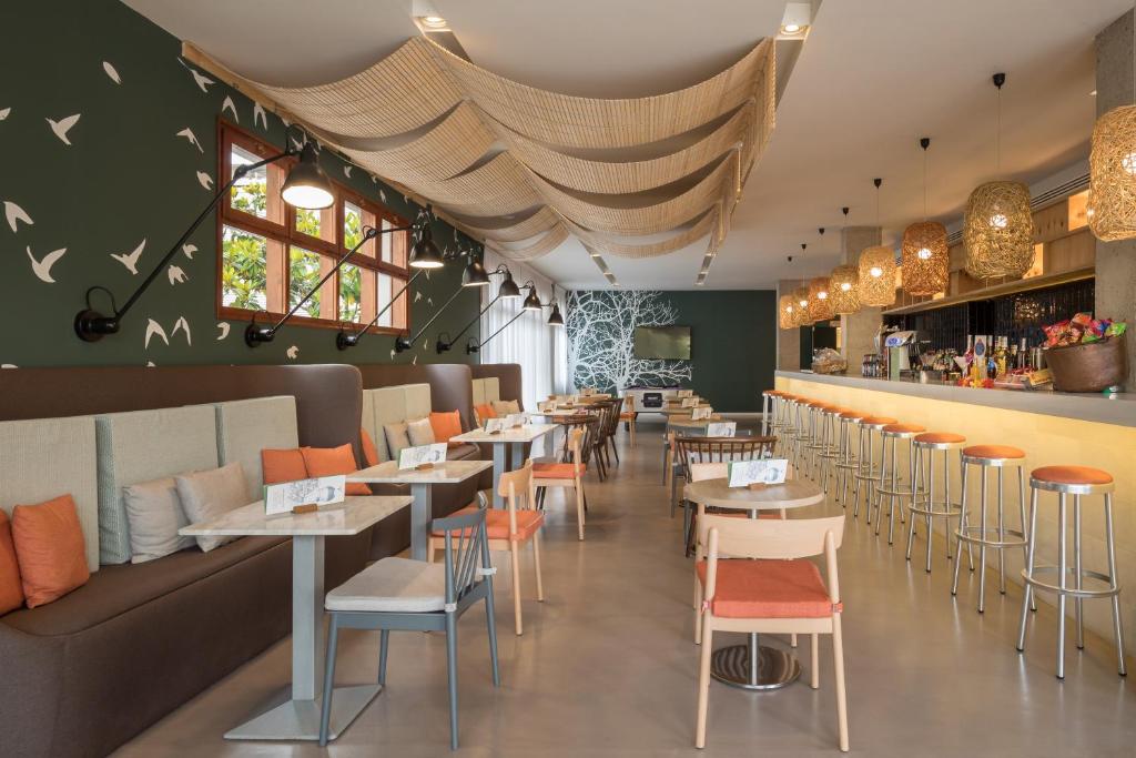 a restaurant with tables and chairs and a bar at AQUA Hotel Bertran Park in Lloret de Mar