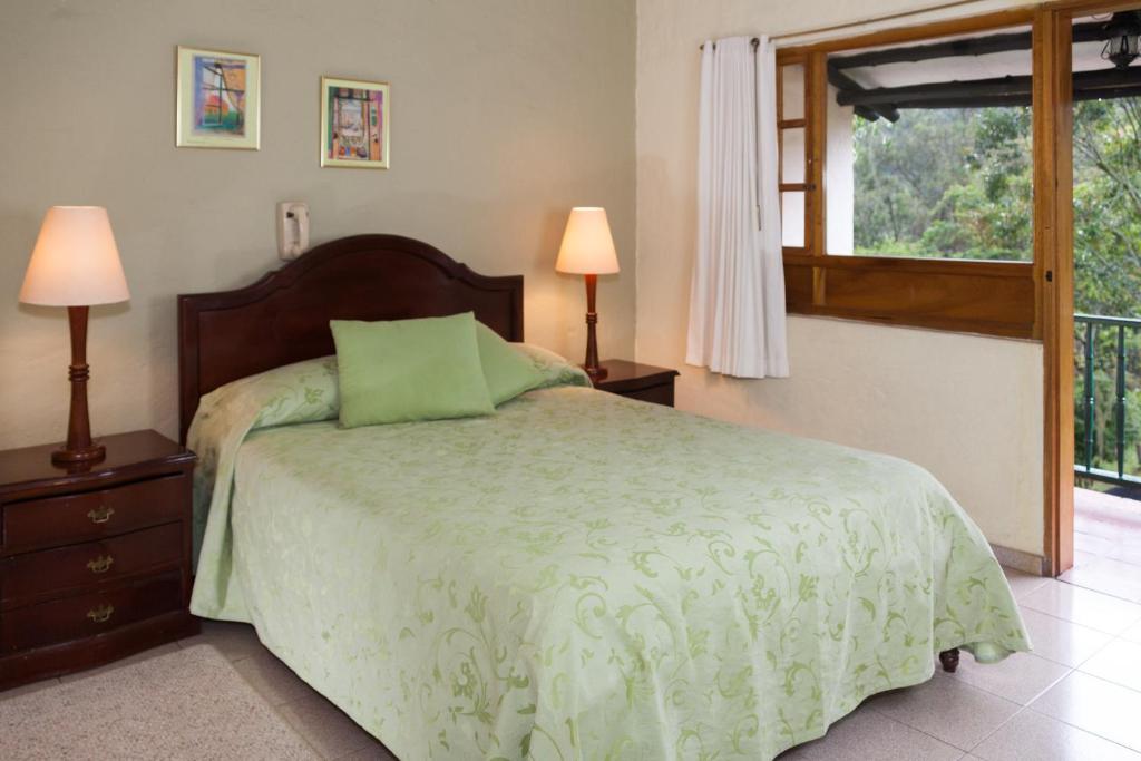 Postel nebo postele na pokoji v ubytování Hotel Campestre Los Arrayanes