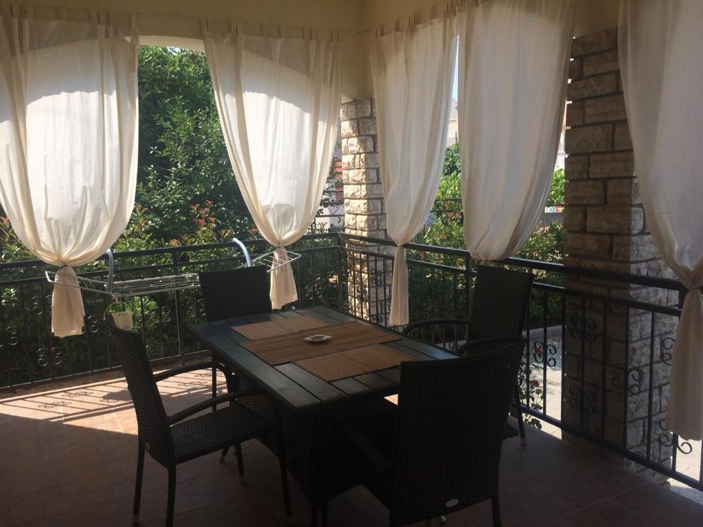 una mesa y sillas en un balcón con cortinas en Srima Angel´s Apartments, en Vodice