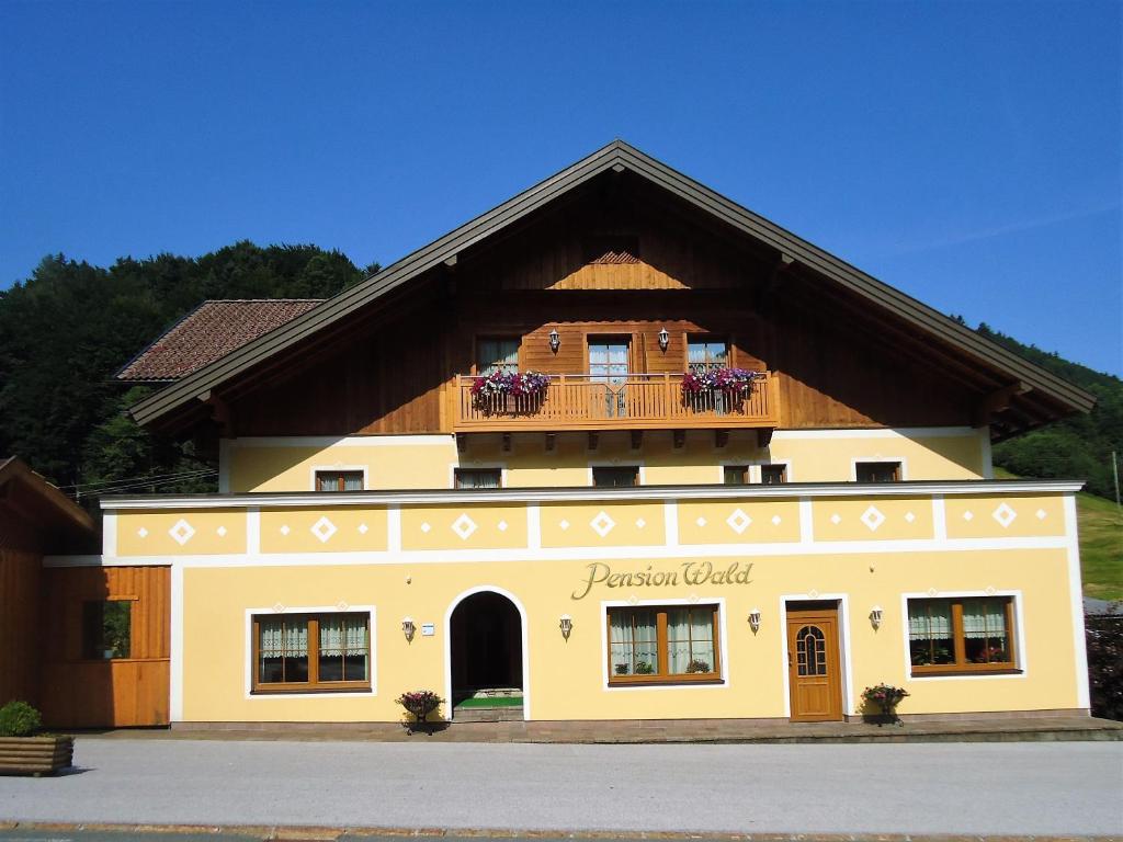 a building with a balcony on top of it at Pension Wald in Faistenau
