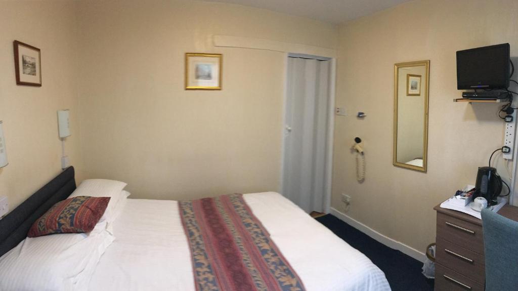a hotel room with a bed and a television at Arkaig Guest House in Aberdeen