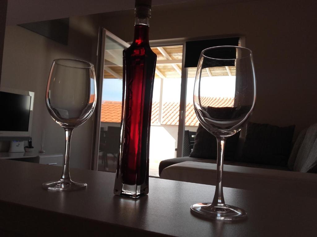 una botella de vino y dos copas de vino en una mesa en Apartment Katarina en Mimice
