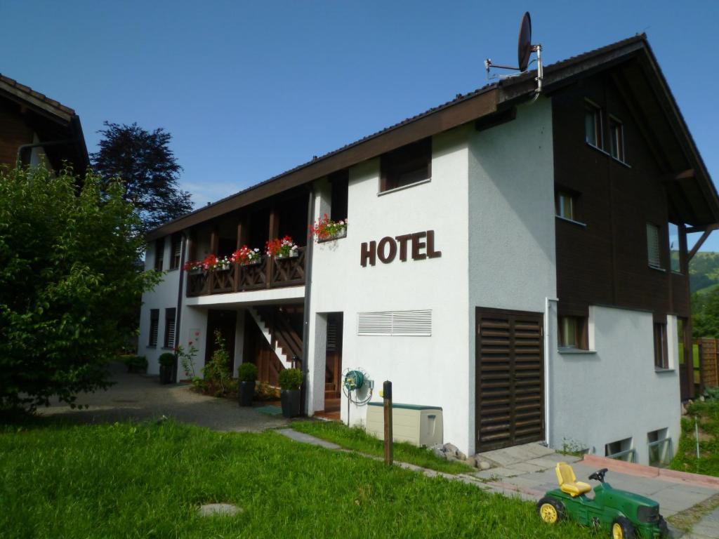 a hotel with a green car in front of it at Hotel Bahnhof in Giswil