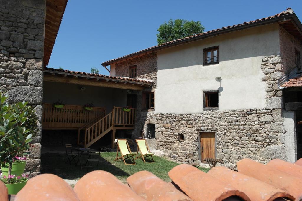 una vista exterior de una casa con sillas en el patio en La Grunonde, en Palogneux