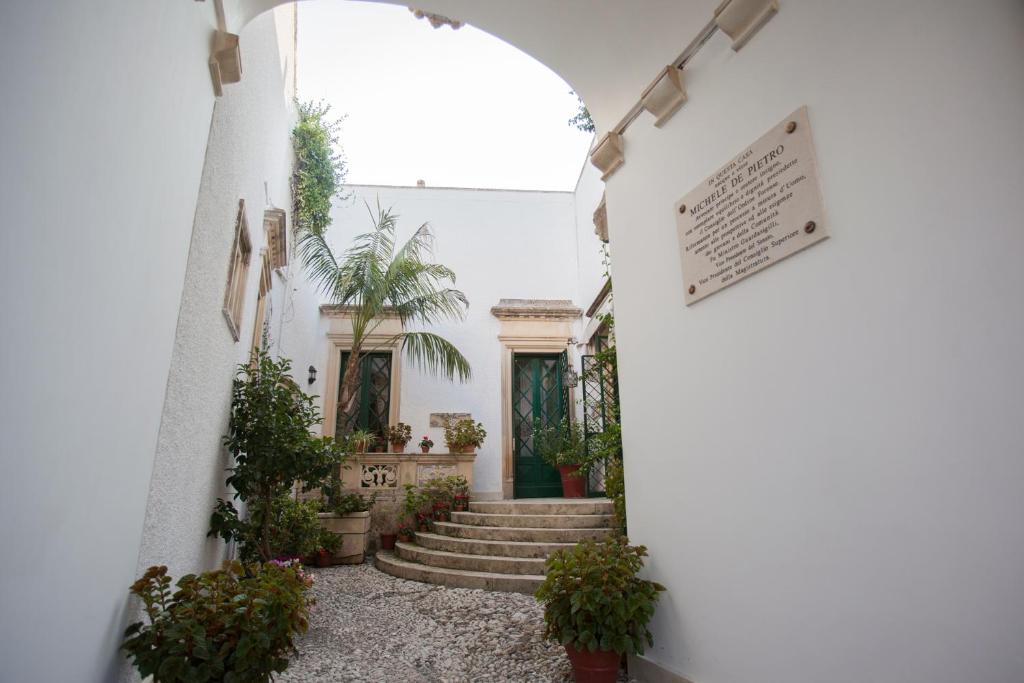 un corridoio con scale e piante in vaso di Villa De Pietro a Cursi