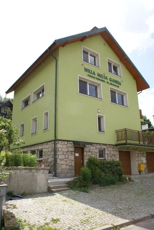 a large green building with a sign on it at Willa Moja Gawra in Lądek-Zdrój