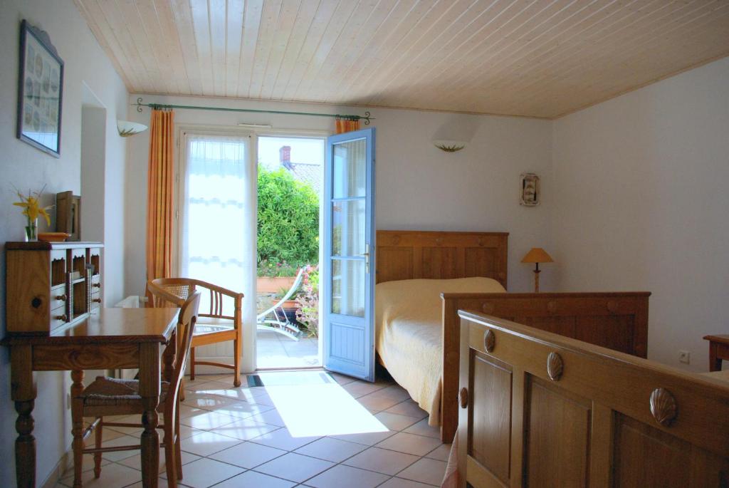 a bedroom with a bed and a table and a door at Chambres d&#39;hôtes - Chez Stephane in L&#39;Ile d&#39;Yeu