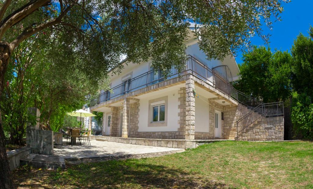 Una gran casa blanca con balcón. en Olive Tree Villa en Herceg-Novi