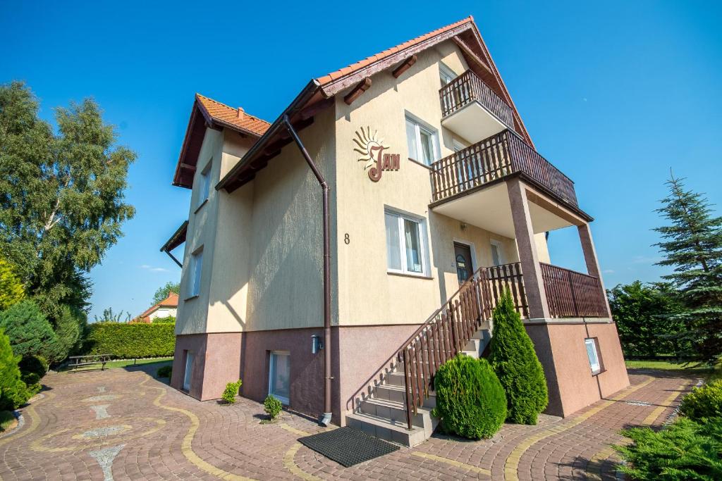 une maison avec un balcon et des escaliers. dans l'établissement Jan Pokoje Dziwnówek, à Dziwnówek