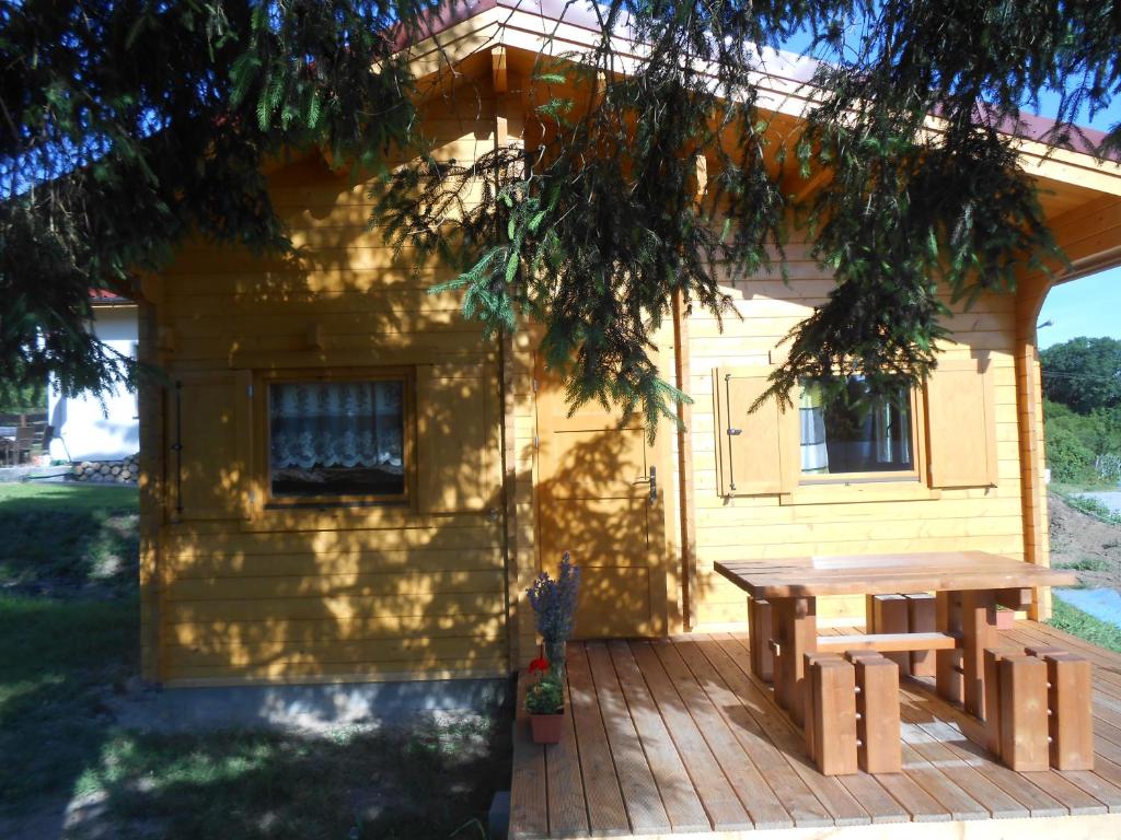 a picnic table on a deck in front of a house at Domek pod Świerkiem in Wapnica