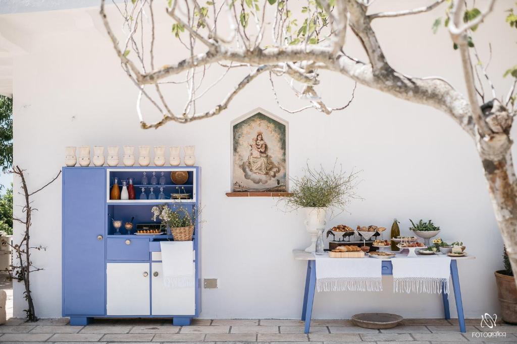 un armario azul junto a una pared blanca con una mesa en Villa de Donatis Charming Guest House, en Casarano