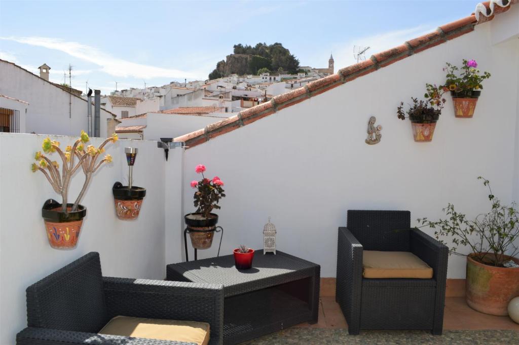 un balcone con 2 sedie e un tavolo con piante di Apartamento Martín ad Ardales