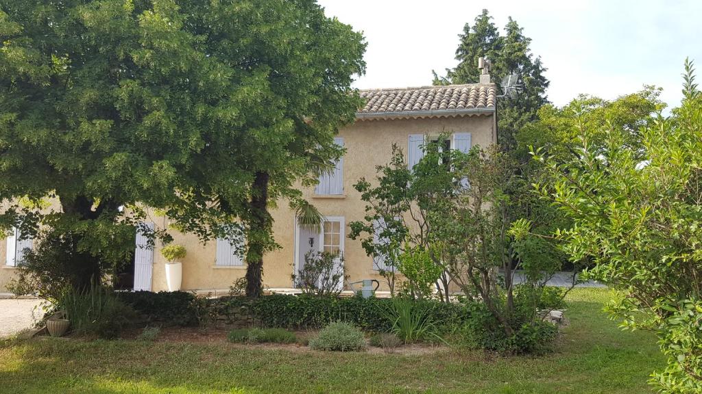 ソルマーヌ・ド・ボークリューズにあるMas des Mûriersの目の前の木々が茂る黄色い家