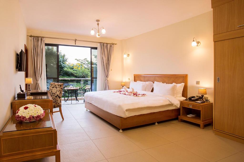 a hotel room with a bed and a balcony at Lotos Inn & Suites, Nairobi in Nairobi