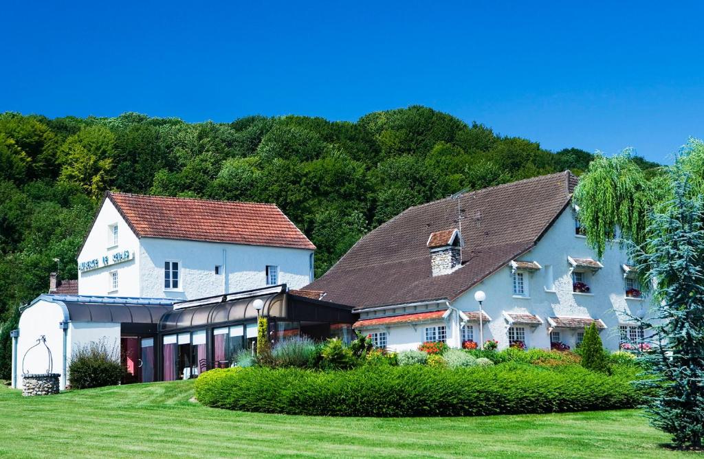 una grande casa bianca su un prato verde di auberge le relais a Reuilly-Sauvigny