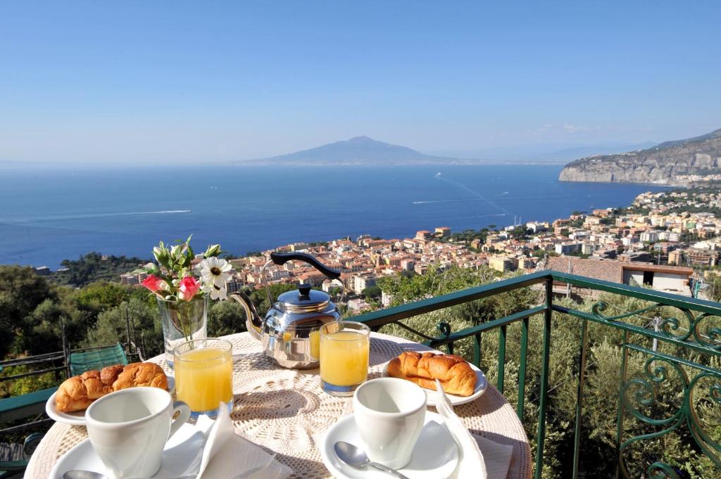 un tavolo con colazione a base di cornetti e succo d'arancia di Casa Vacanze Chery a Sorrento