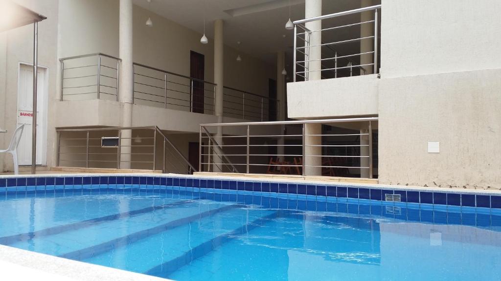 a large blue swimming pool in a building at Hana Praia Hotel in Camocim