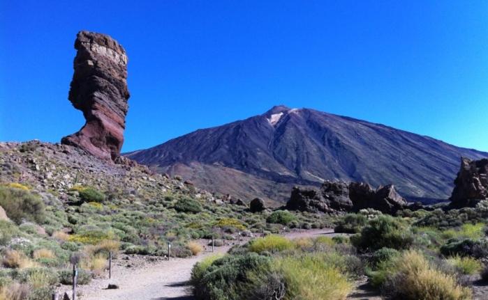 een berg in het midden van een woestijn met een onverharde weg bij Marody Tenerife House in El Médano