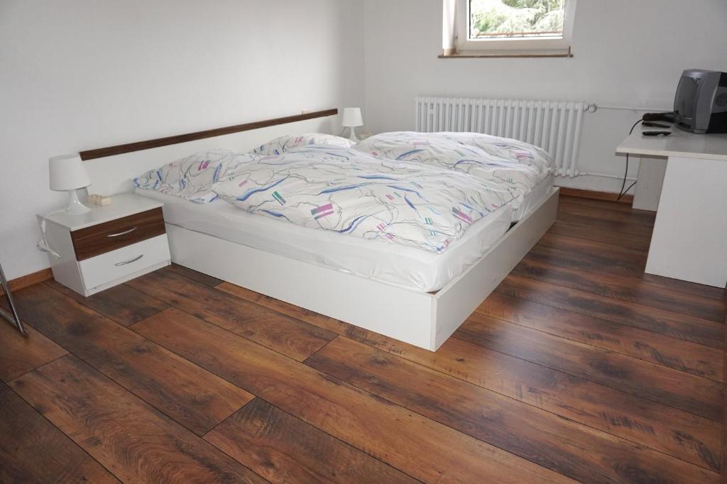 Schlafzimmer mit einem Bett und Holzboden in der Unterkunft Artus Hotel in Düsseldorf