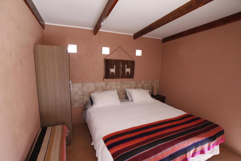 um quarto com uma grande cama branca num quarto em Hostal Casa Turipite em San Pedro de Atacama