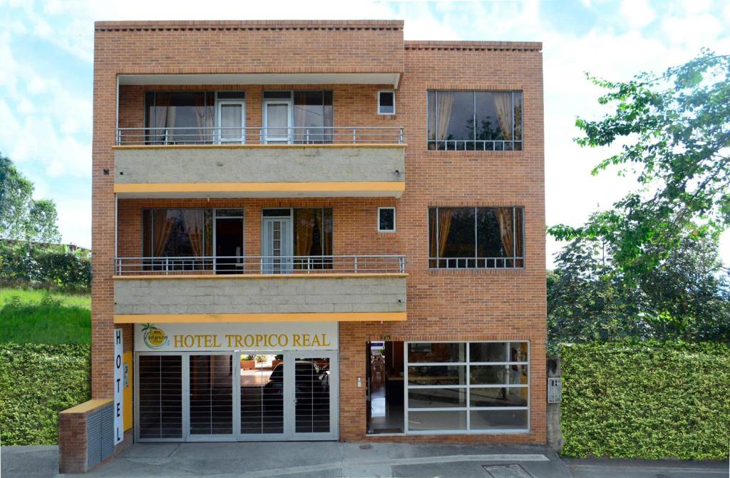 un edificio de ladrillo con un hotel subterráneo en Hotel Tropico Real Mesitas en El Colegio