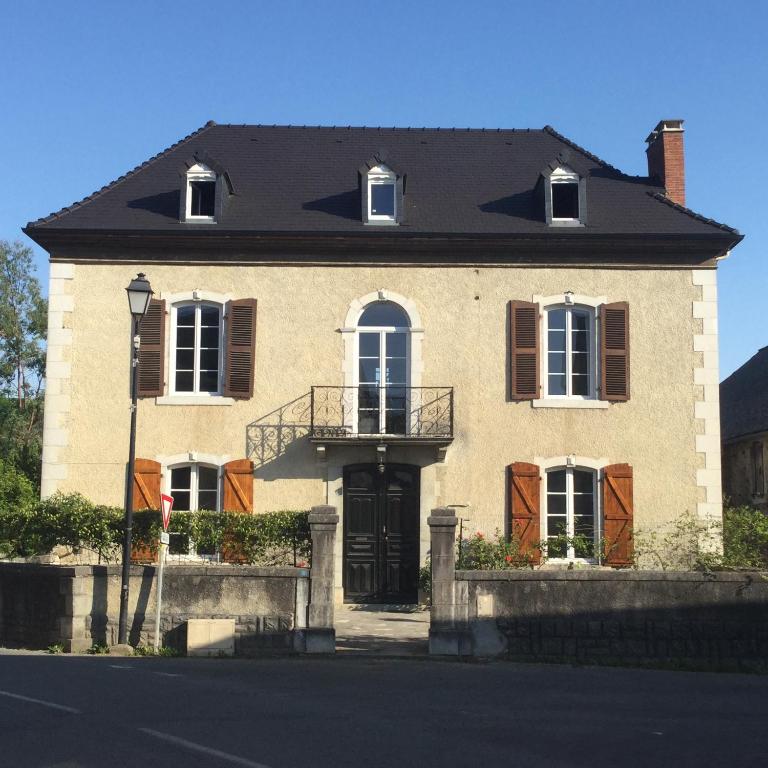 une grande maison en briques avec un toit noir dans l'établissement Chez Susan, à Buzy