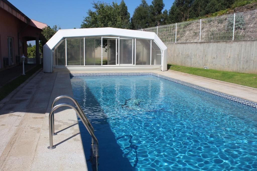 a swimming pool in front of a glass house at Vila Porto in Vila Nova de Gaia