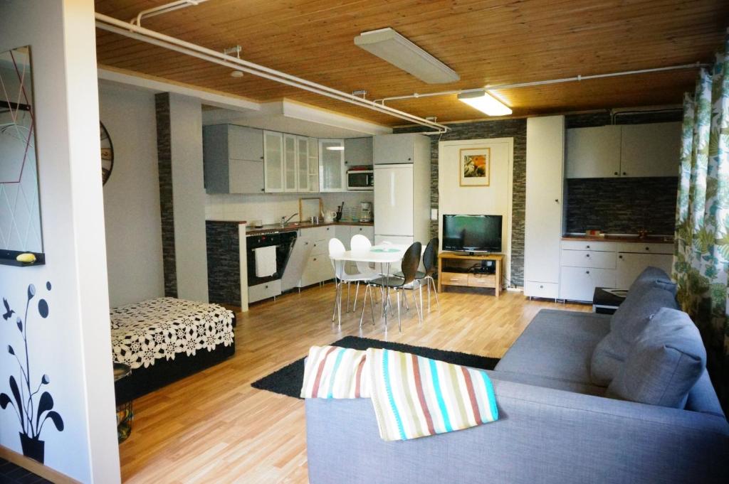 a living room with a blue couch and a kitchen at Åker Kristinagården in Skillingaryd