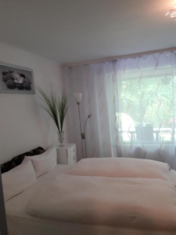 a white bedroom with two beds and a window at Apartment near Villa Turgenev in Baden-Baden