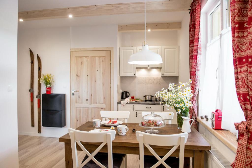 a kitchen and dining room with a wooden table and chairs at Willa Malta in Zakopane