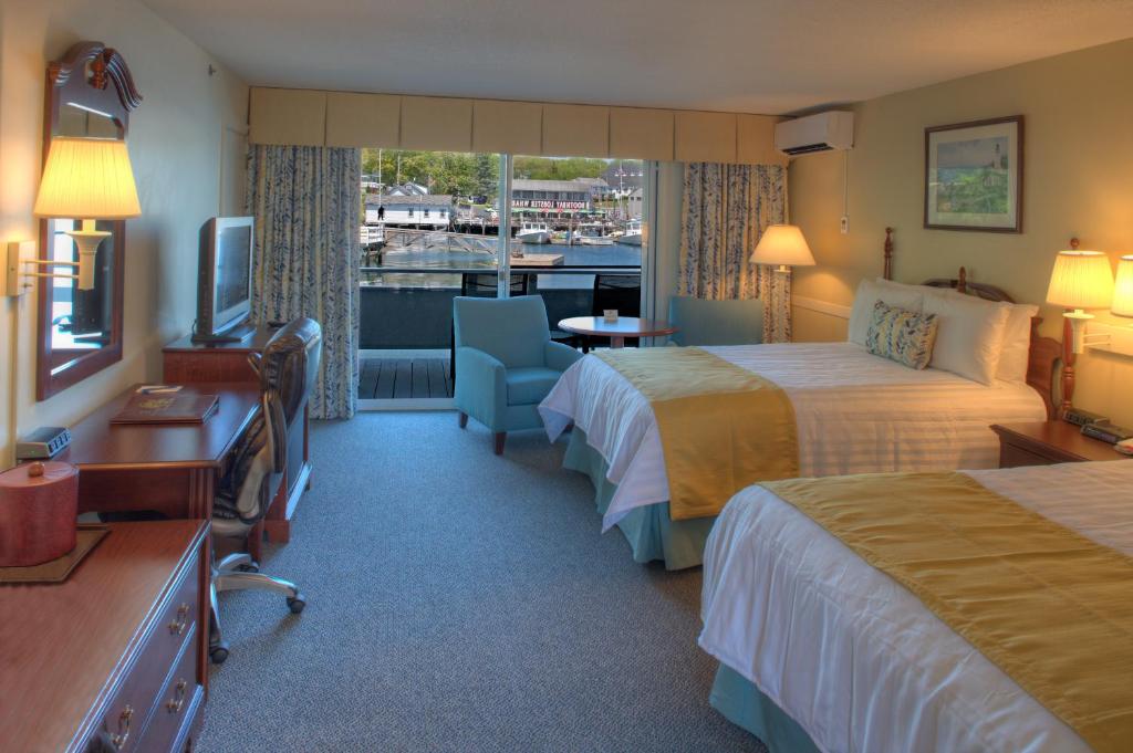a hotel room with two beds and a television at Browns Wharf Inn in Boothbay Harbor