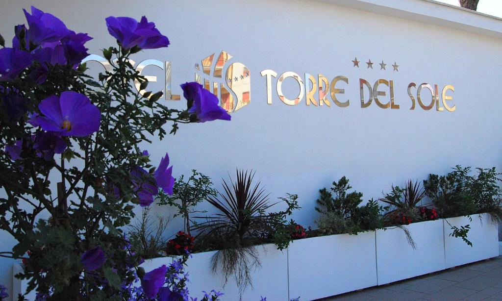 a sign on the side of a building with purple flowers at Torre Del Sole in Terracina