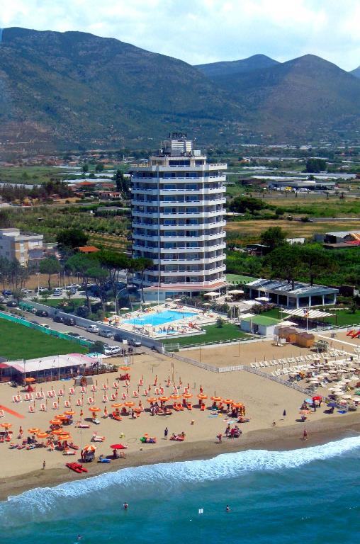 a beach with a lot of people and a large building at Torre Del Sole in Terracina