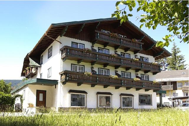 um grande edifício branco com varandas em cima em Appartementhaus Huber em Abersee