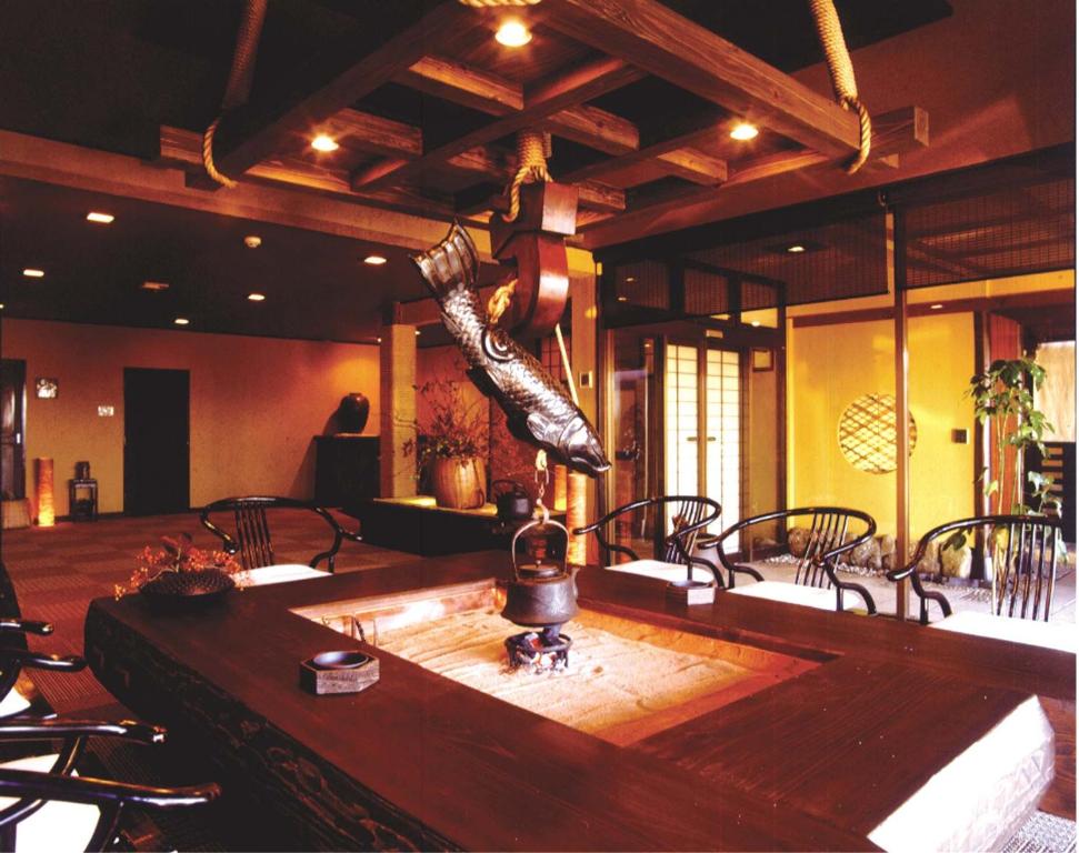 Habitación con una gran mesa de madera y sillas. en Omoideno Jinde en Izu