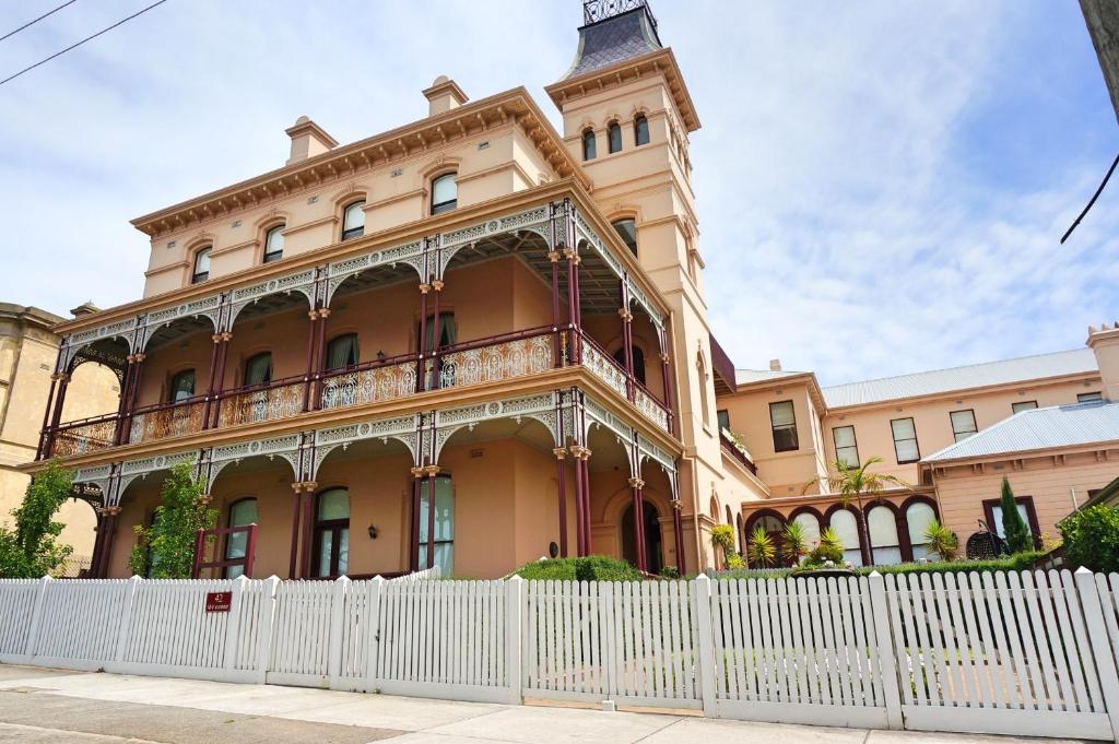 a building with a white fence in front of it at Ozone Tower in Queenscliff