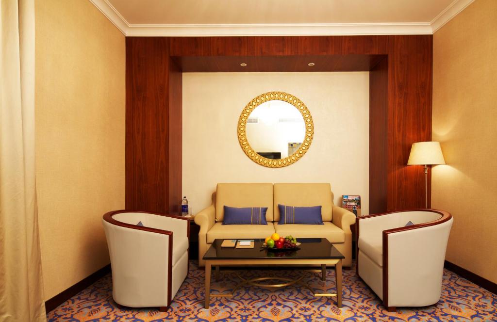 a living room with a couch and a table and chairs at Raviz Center Point Hotel in Dubai