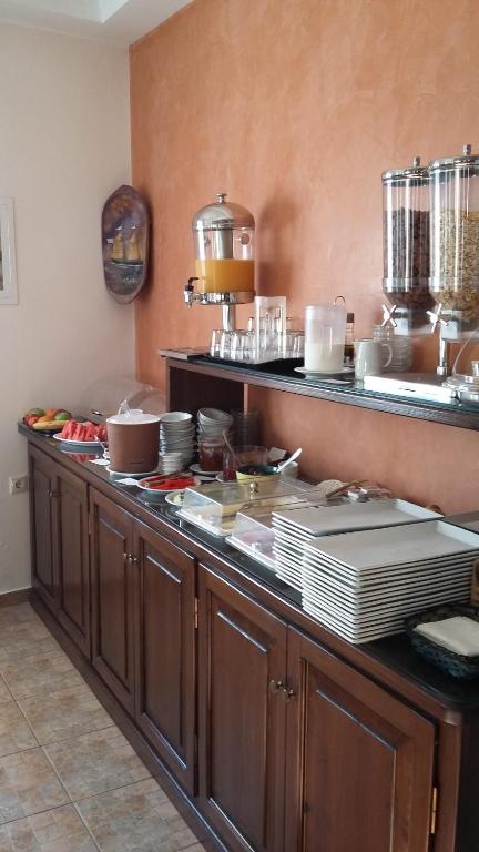 a kitchen with a counter with plates and pots and pans at Anemoessa Villa in Oia