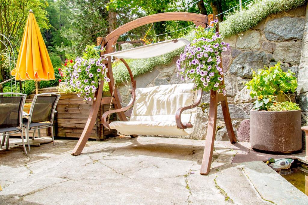 a chair with flowers and an umbrella on a patio at Alpenblick in Zermatt