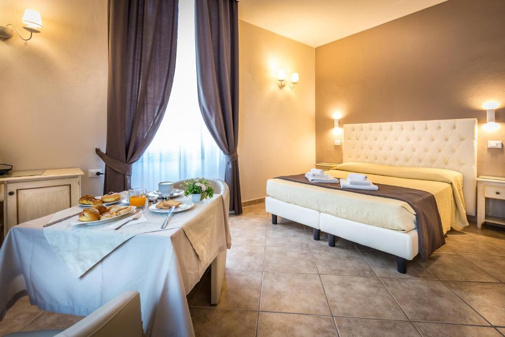 una habitación de hotel con 2 camas y una mesa con comida. en Sognando Firenze, en Florencia