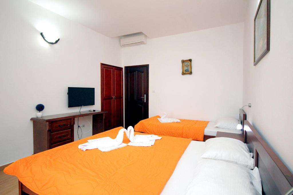 a room with two beds and a television in it at Apartmani More in Sveti Stefan