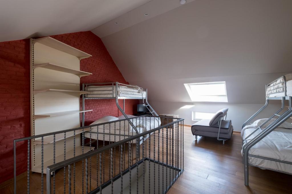 a attic room with two bunk beds and a chair at Sekowa-lodge in Geraardsbergen