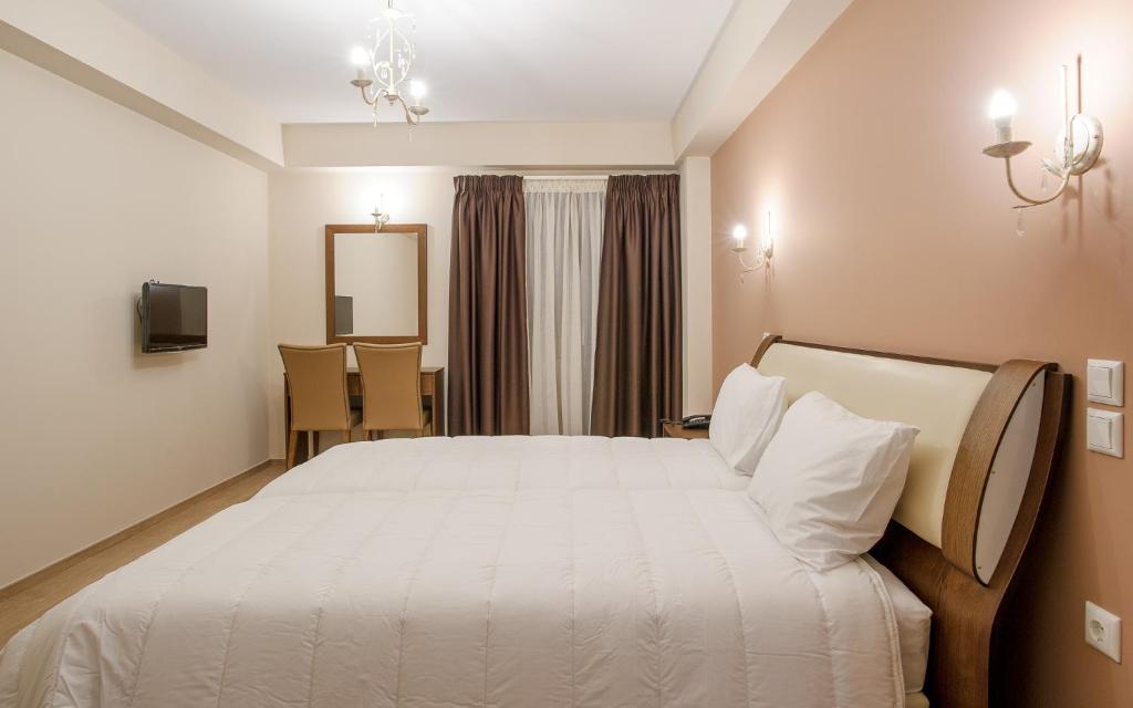 um quarto com uma grande cama branca num quarto em Hotel Anna em Ioannina
