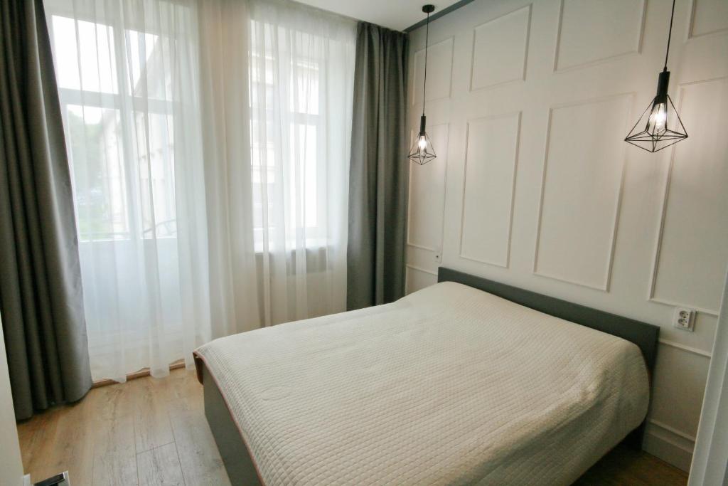 a bedroom with a bed and a window and lights at Historical Centre Apartments in Lviv