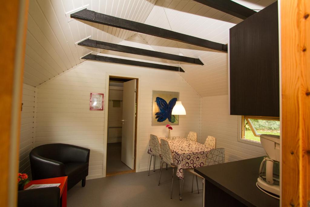 a kitchen and dining room with a table and chairs at Husodde Strand Camping & Cottages in Horsens