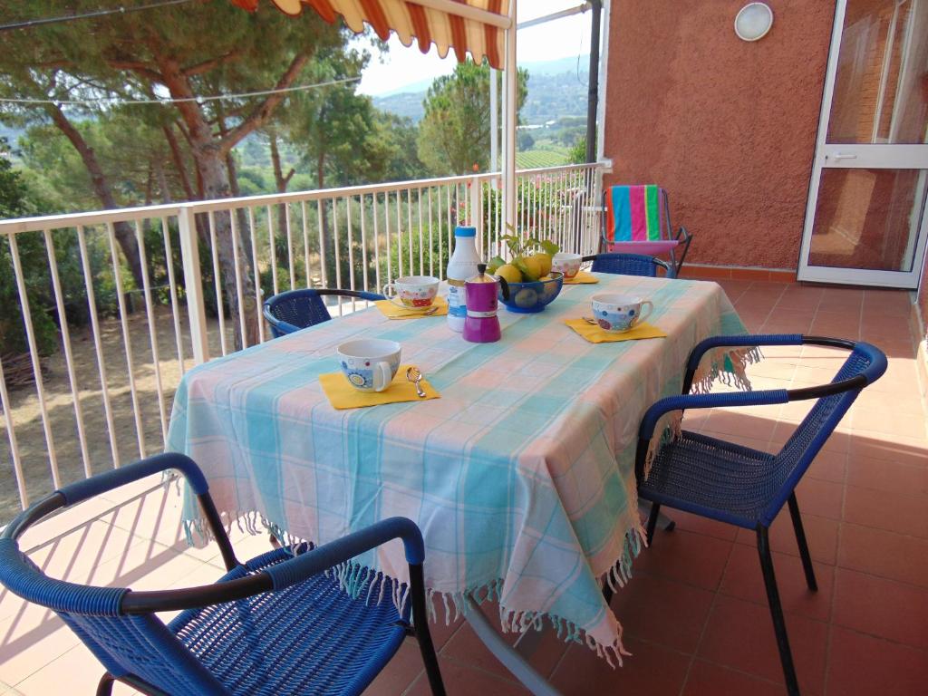 uma mesa com uma toalha de mesa azul numa varanda em Appartamenti Gli Alberi em Capoliveri