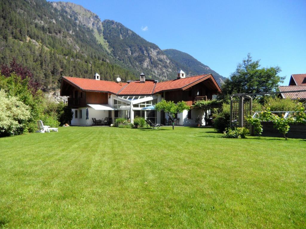 una casa con un gran patio frente a una montaña en Haus Salzmann, en Pfunds
