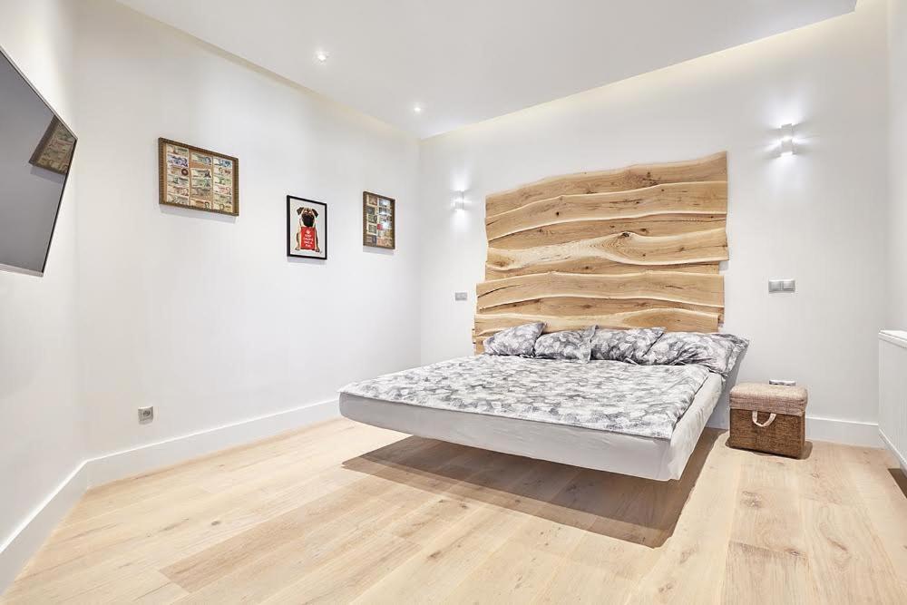 um quarto branco com uma cama e uma parede de madeira em Blue Door Apartment em Augustów
